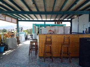 un bar con tre sgabelli di legno intorno di My Hostel in Dahab - Dive center a Dahab