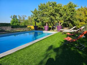 a swimming pool with two lawn chairs next to it at Domaine Bassy in Saint-Gengoux-de-Scissé