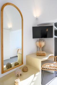 a mirror in a room with a table and a chair at Hypnōs boutique villa with amazing heated pool with jacuzzi in Fira