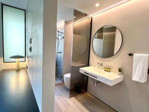 a bathroom with a sink and a mirror at Feelathome Nervión Apartments in Seville