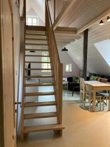 a wooden staircase in a living room with a table at Domek Kavalírek in Lipova Lazne
