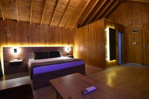 1 dormitorio con 1 cama y pared de madera en Sandal Otel, en Trabzon