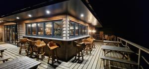a bar with chairs and tables on a deck at Zen Jungle Retreat - Log Cabin Stays, Transformational Retreats & Holistic Wellness near Bude - A 40 Acre Retreat with 5 Lakes, Woodland, Firepits, Bistro & Bars in Holsworthy