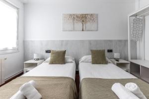 1 dormitorio con 2 camas y toallas. en Portu Style by Aston Rentals, en Portugalete