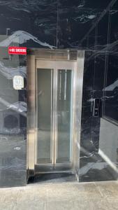 een zilveren lift in een gebouw met een bord erop bij Shivjot hotel in Kharar