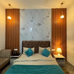 a bedroom with a large bed with blue pillows at Shivjot hotel in Kharar