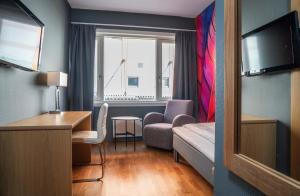 a hotel room with a desk and a chair and a window at Thon PartnerHotel Storgata in Kristiansund