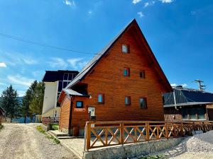 Duża czerwona stodoła z drewnianym płotem wokół niej w obiekcie Holiday Home Krajina II w mieście Vlašić
