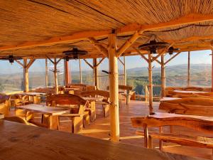 a large wooden pavilion with wooden tables and chairs at Ethno village Molitva in Družiniće