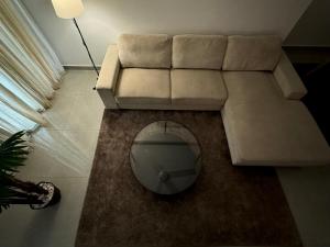 a living room with a couch and a mirror at Cozy Apartment in Boshar in Muscat