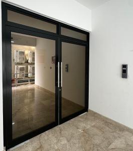 an entrance to a building with glass doors at Cozy Apartment in Boshar in Muscat +9 photos