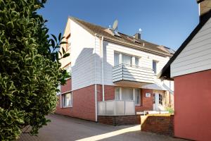 een wit en rood huis met een rode baksteen bij Hummerklippen Ferienwohnungen in Helgoland