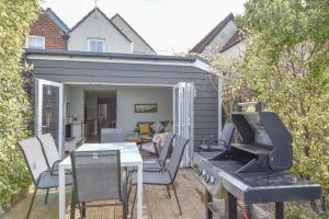 a patio with a grill and a table and chairs at Blackberry Cottage in Bembridge