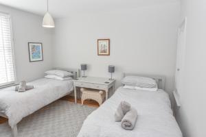 two twin beds in a room with a table at Blackberry Cottage in Bembridge