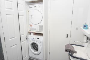 a white laundry room with a washer and dryer at Blackberry Cottage in Bembridge