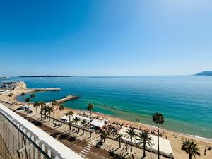 widok na plażę z palmami i ocean w obiekcie Superbe Penthouse avec vue panoramique sur la mer w Cannes