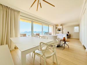 salon z białym stołem i krzesłami w obiekcie Superbe Penthouse avec vue panoramique sur la mer w Cannes