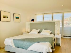 sypialnia z dużym łóżkiem z białymi poduszkami w obiekcie Superbe Penthouse avec vue panoramique sur la mer w Cannes