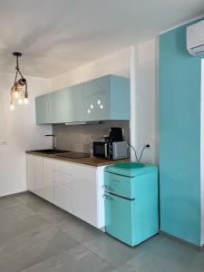 eine Küche mit weißen Schränken und einem blauen Kühlschrank in der Unterkunft Bellissima Cervo in Cervo