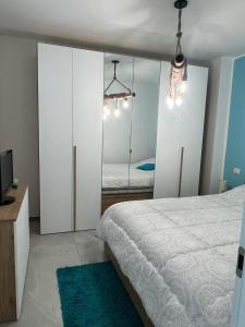 Schlafzimmer mit weißen Schränken und einem Bett mit Spiegel in der Unterkunft Bellissima Cervo in Cervo