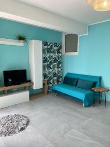 uma sala de estar azul com um sofá e uma televisão em Bellissima Cervo em Cervo