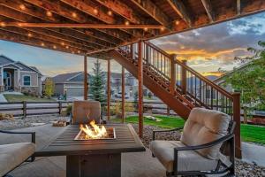 a patio with a table and chairs and a fireplace at Room to Spread Out & Deck with Mountain Views in Monument