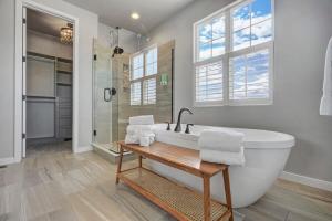 a white bathroom with a tub and a shower at 4BR Mountain views - Movie Theater - Pool Table in Monument
