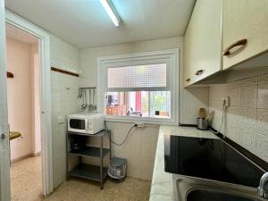 a kitchen with a microwave and a window at La Oca - Aloturin Benidorm in Benidorm