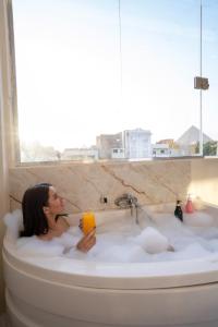 a woman sitting in a bath tub with a drink at King of Pharaohs INN pyramids in Cairo