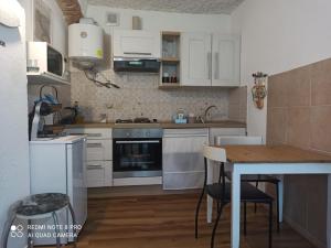 a kitchen with white cabinets and a wooden table at La Maisonette in Sori