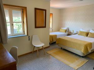 ヴィアナ・ド・カステロにあるエンジョイ ヴィアナ ゲスト ハウスのベッド2台と窓が備わるホテルルームです。