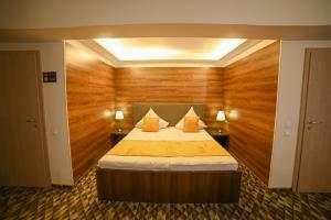 a bedroom with a large bed with wooden walls at No 107 Predeal in Predeal