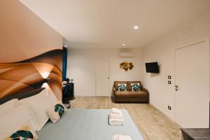 ein Schlafzimmer mit einem Bett und einem Sofa in einem Zimmer in der Unterkunft Vimini Corso Cavour - City Center in Bari