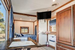 einen Esstisch in einem Wohnwagen mit einem TV an der Decke in der Unterkunft Prairie Place in Palmer Lake