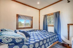 1 dormitorio con cama con edredón azul y ventana en Prairie Place, en Palmer Lake