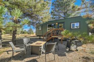 una casita verde con mesa de picnic y sillas en Prairie Place, en Palmer Lake