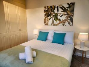 1 dormitorio con 1 cama grande con almohadas azules en Gilpin villa 4Bedroom WiFi, Parking, Netflix, Garden en Gloucester