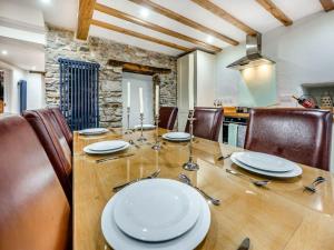 a dining room with a wooden table and chairs at Blacksmiths Cottage in Pembroke