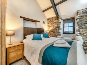 a bedroom with a large bed with blue pillows at Blacksmiths Cottage in Pembroke