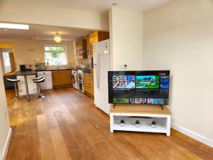 a kitchen with a large television in a living room at Gilpin villa 4Bedroom WiFi, Parking, Netflix, Garden in Gloucester