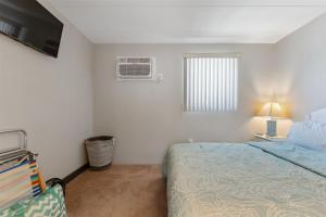 1 dormitorio con cama, ventana y TV en 422 E 4th Ave, Unit 206, en North Wildwood