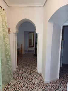 un pasillo con paredes blancas y un arco en Apartamentos Abderraman I, en Córdoba