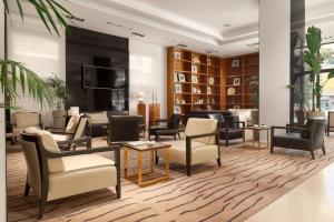 un vestíbulo con sofás, mesas y sillas en Hotel Atrium en Split