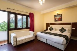 a bedroom with a bed and a chair and windows at Hotel Cottage Orchid Nainital - Parking Facilities - Luxury & Hygiene Room - Best Seller in Nainital