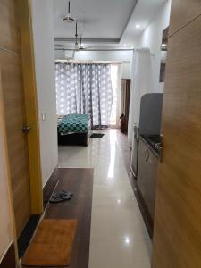 een kamer met een gang met een bed en een raam bij Vision Studio Apartment in Ghaziabad