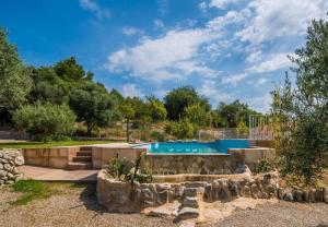 una piscina in un cortile con un muro in pietra e alberi di Villa Ses Comes a Selva