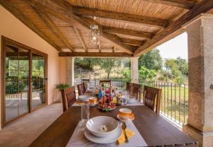 uma sala de jantar exterior com mesa e cadeiras em Villa Ses Comes em Selva