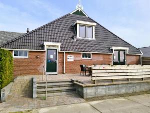 een stenen huis met een patio en een tafel bij B&B De Kan Hoeve in De Veenhoop