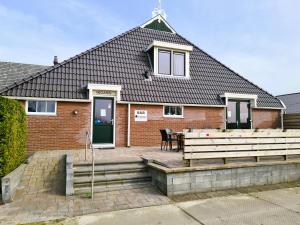 a brick house with a patio and a table at B&B De Kan Hoeve in De Veenhoop