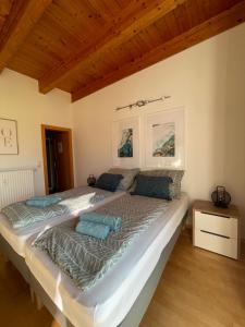 een groot bed in een kamer met houten plafonds bij Apartment Sommer am Faaker See in Faak am See